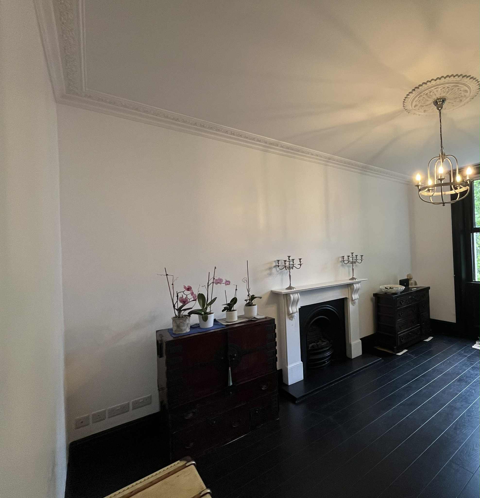 Completed bright living room with period fireplace and decorative cornices
