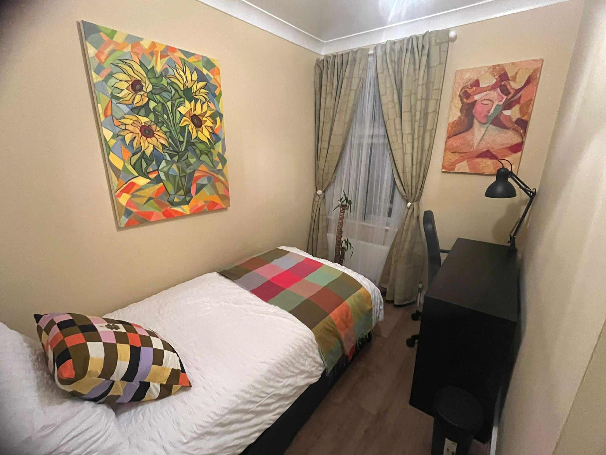 Styled bedroom with colourful artwork and coordinated soft furnishings